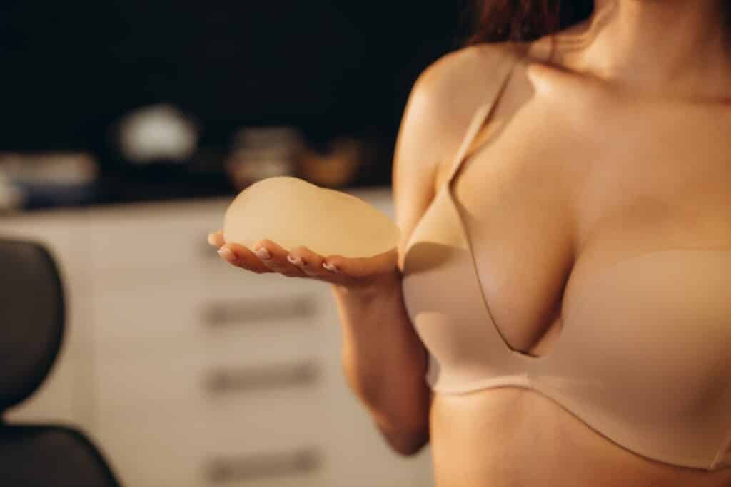 Woman holding breast implant considering breast augmentation surgery in National Harbor, Maryland